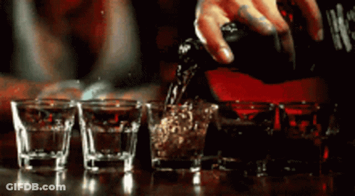 Person Pouring Shot Into Shot Glasses GIF