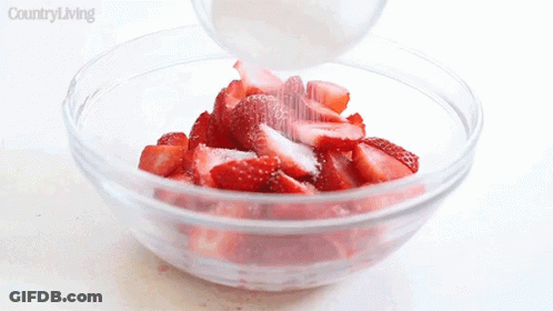 Person Pouring Sugar Into Strawberries In Glass Bowl GIF