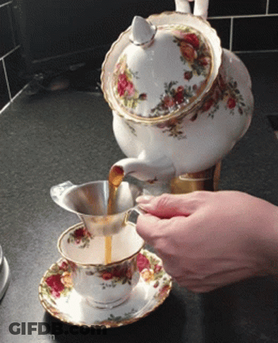 Person Pouring Tea From Teapot Into Cup GIF