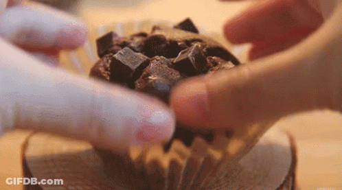 Person Putting Chocolate Chips In Chocolate Cupcake GIF