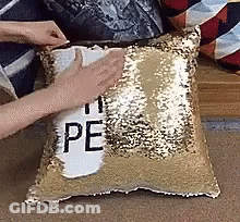 Person Putting Pillow With Peace On Couch GIF