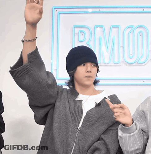 Person Raising Hand By Neon Sign Saying Rmuo GIF