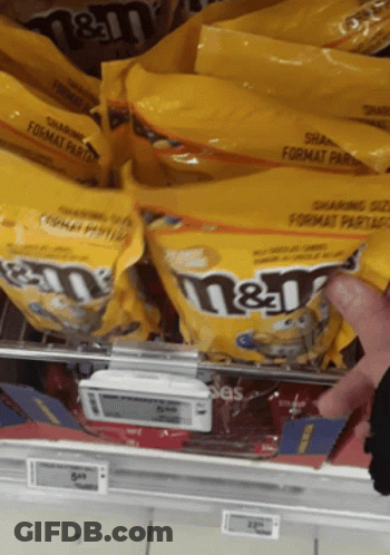 Person Reaching For Bag Of M&M's GIF