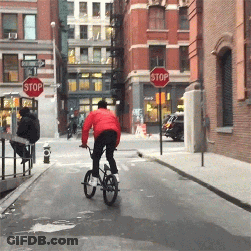 Person Riding Bike At Stop Sign GIF