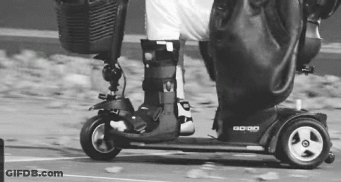 Person Riding Mobility Scooter In Black And White GIF