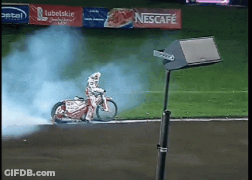 Person Riding Motorcycle On Track With Nescafe Banner GIF