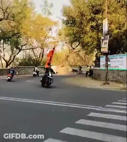 Person Riding Motorcycle With Red Flag GIF