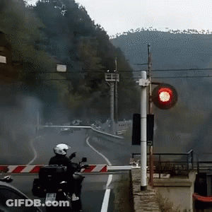 Person Riding Motorcycle With Red Light Behind GIF