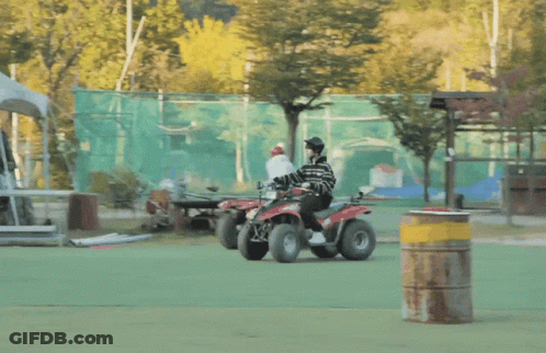 Person Riding Red And Black ATV On Green Field GIF