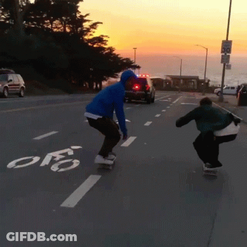 Person Riding Skateboard On Street With Bike Lane GIF