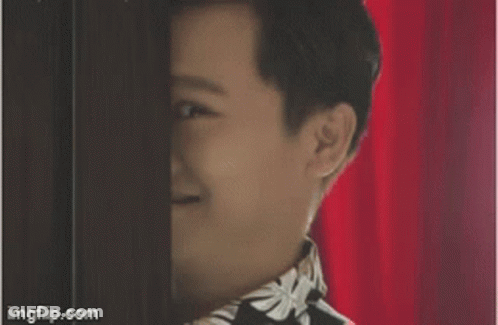 Person's Face Behind Red Curtain GIF