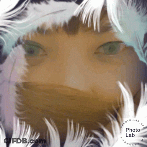 Person's Face Surrounded By White Feathers GIF