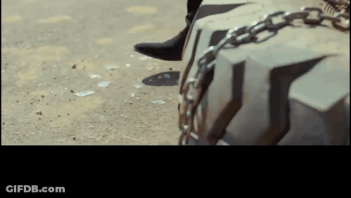 Person's Foot Chained To Tire GIF