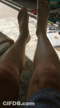 Person's Legs Laying On Tiled Floor GIF