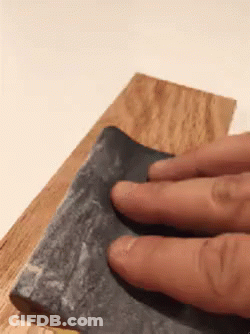 Person Sanding Wood With Fingers On Sandpaper GIF