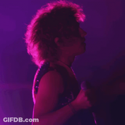 Person Singing Into Microphone In Dark Room GIF