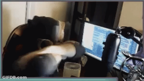 Person Sitting At Desk With Computer And Microphone GIF