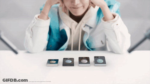 Person Sitting At Table With Row Of Phones GIF