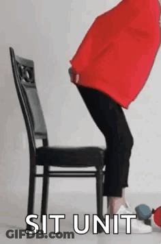 Person Sitting Cross-Legged On Chair With Red Pillow GIF