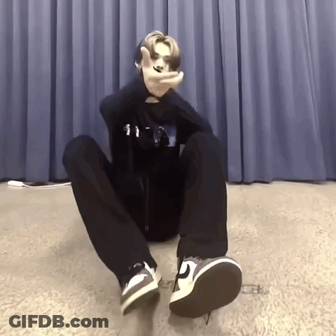 Person Sitting Crossed Legs Making Peace Sign GIF