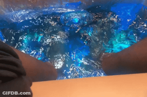 Person Sitting In Bathtub With Blue Water GIF