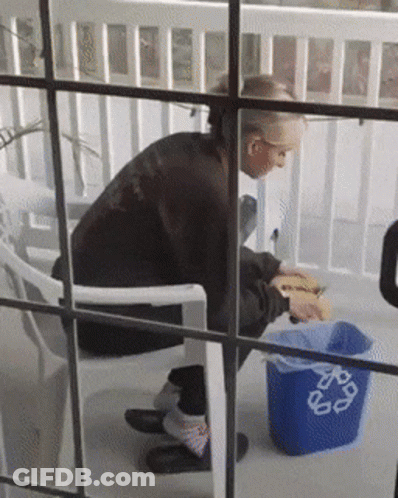 Person Sitting Next To Blue Recycle Trash Can GIF