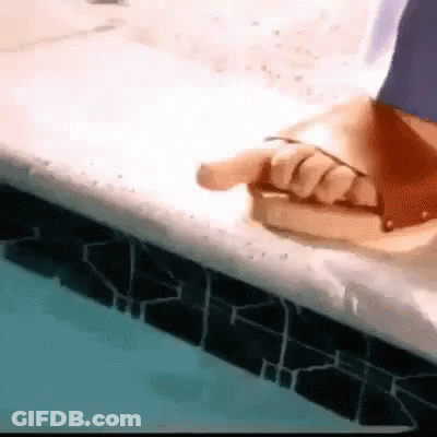 Person Sitting On Pool Edge Pointing At Book GIF