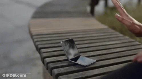 Person Sitting On Wooden Bench With Cell Phone GIF