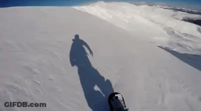 Person Snowboarding Down Snowy Hill GIF