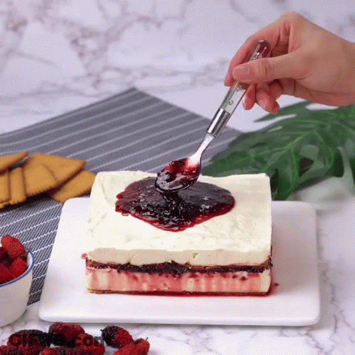 Person Spreading Berry Sauce On Cake GIF