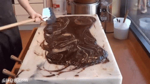Person Spreading Chocolate On Cutting Board GIF