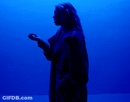 Person Standing Before Large Blue Light GIF