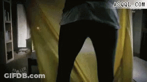 Person Standing Before Yellow Curtain GIF
