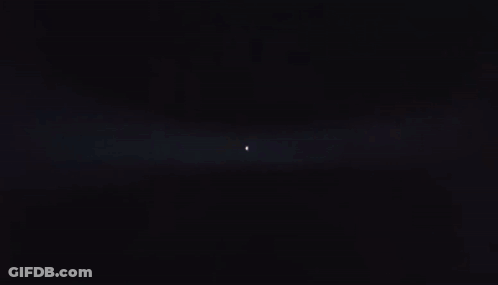Person Standing In Dark Room With Light Shining GIF