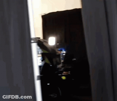 Person Standing In Dark Room With Light GIF
