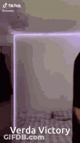 Person Standing In Front Of Bed With Purple Lights GIF