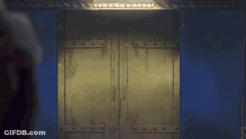 Person Standing In Front Of Door With Light Shining GIF