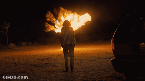 Person Standing In Front Of Fire With License Plate Saying RC GIF