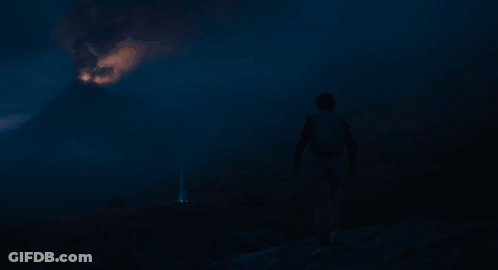 Person Standing In Front Of Fireball In Dark GIF