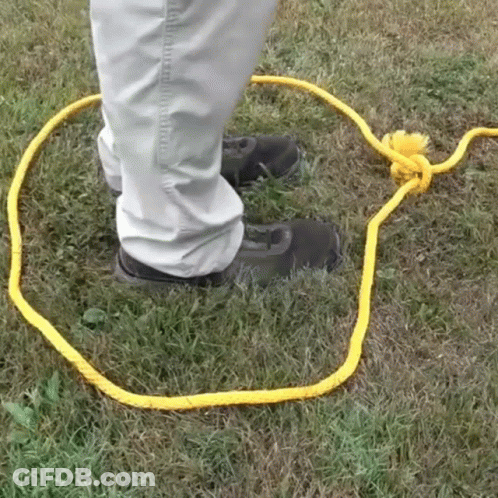 Person Standing In Grass With Yellow Rope GIF
