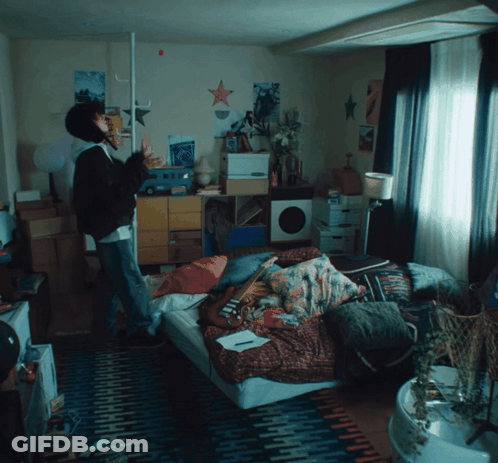 Person Standing In Room With Posters And Bed GIF