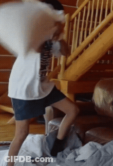 Person Standing On Bed With Pillow On Back GIF