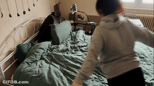 Person Standing On Bed With Tablet GIF