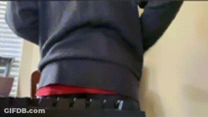 Person Standing On Chair With Outstretched Arms In Red Shirt GIF