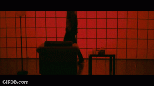 Person Standing On Couch In Front Of Red Screen GIF
