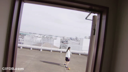 Person Standing On Rooftop With City View GIF