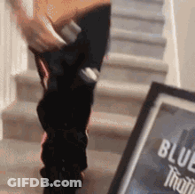 Person Standing On Stairs Next To Blue Bottle GIF