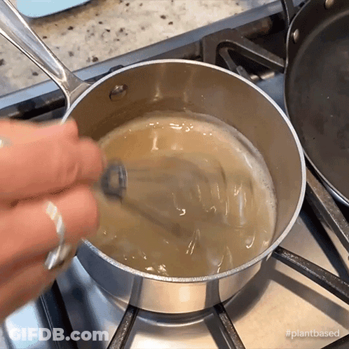 Person Stirring Liquid In Pot GIF
