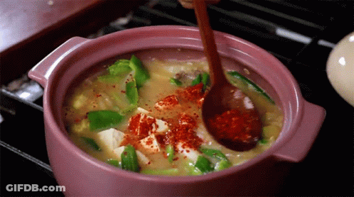 Person Stirring Pot Of Food With Spoon GIF