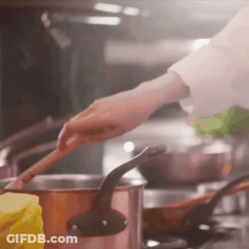 Person Stirring Pot Of Food With Wooden Spoon GIF